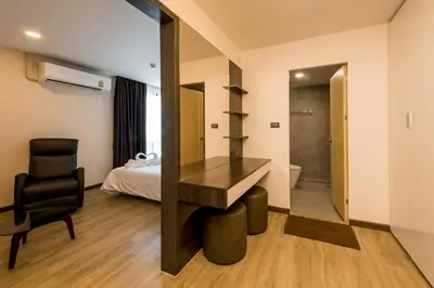 a room with a mirror and a desk and a bed at Zensation The Residence in Bangkok