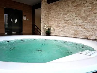 a bath tub filled with water in a bathroom at Zensation The Residence in Bangkok