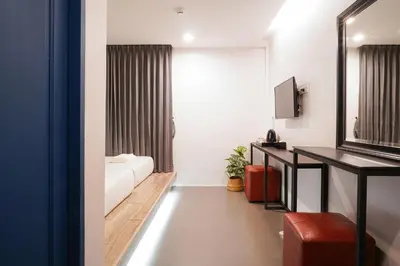 a hotel room with a bed and a mirror at Marwin Space in Bangkok