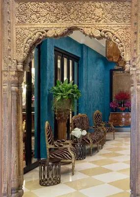 a room with chairs and a table and a blue wall at Sara's Hotel in Bangkok