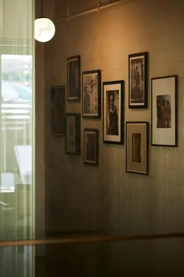 a group of framed pictures on a wall at Josh Hotel in Bangkok