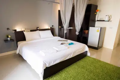 a bedroom with a large white bed with a green rug at A18 in Nonthaburi