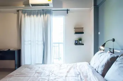 a bedroom with a bed and a window at A18 in Nonthaburi