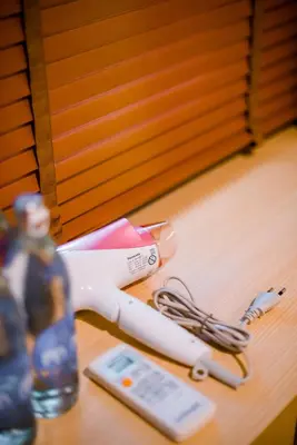 a hair dryer sitting on a table next to a cell phone at GN Luxury Hostel in Bangkok