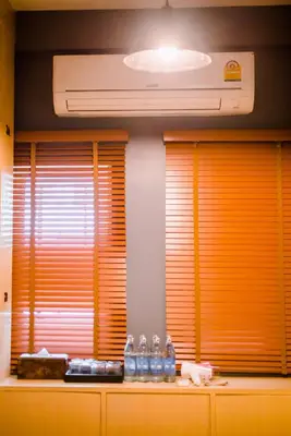 a kitchen with two windows with bottles of water at GN Luxury Hostel in Bangkok
