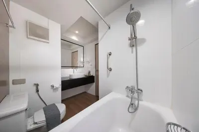 a white bathroom with a tub and a sink at At 115 Hotel By Rompo in Bangkok