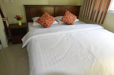 a bedroom with a large white bed with two pillows at The Best Place in Samutprakarn