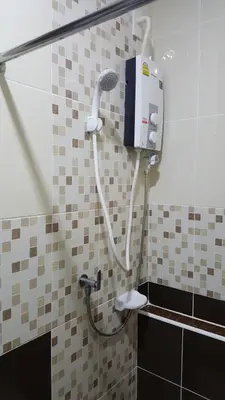 a shower in a tiled bathroom with a shower head at The Best Place in Samutprakarn