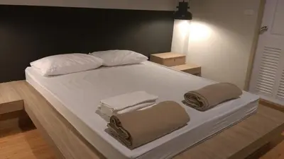 a bed with two towels and two pillows on it at Inn Stations Hostel in Bangkok