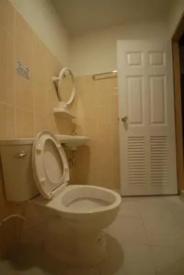 a bathroom with a toilet with a mirror and a door at Inn Stations Hostel in Bangkok