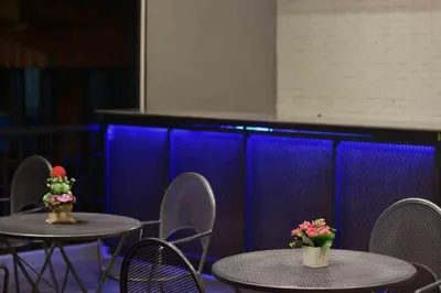 two tables and chairs with flowers on top of them at Inn Stations Hostel in Bangkok