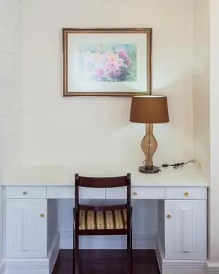 a white desk with a lamp and a chair at The Lek Aree in Bangkok