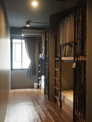 a room with two bunk beds and a window at Silom Space Hostel in Bangkok