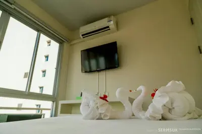 two white swans sitting on top of a bed at Right Place Sathorn in Bangkok