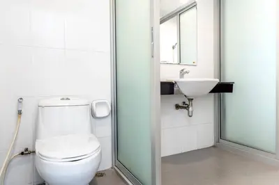 a bathroom with a toilet and a sink at Right Place Sathorn in Bangkok