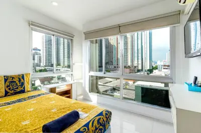 a bedroom with a bed and a large window at Right Place Sathorn in Bangkok