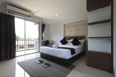 a bedroom with a bed and a large window at Q Space Residence in Bangkok