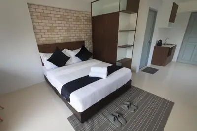 a bedroom with a large bed and a mirror at Q Space Residence in Bangkok