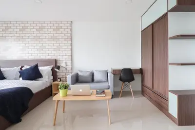 a bedroom with a bed and a table with a laptop at Q Space Residence in Bangkok
