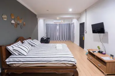 a bedroom with a large bed and a television at Pann Residence in Bangkok