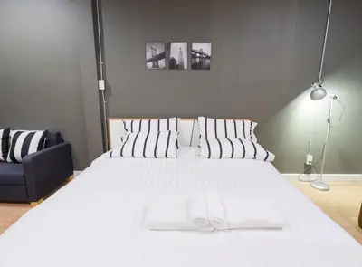 a bedroom with a large white bed and a blue chair at Pann Residence in Bangkok