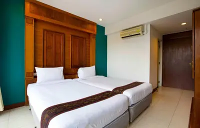 two beds in a room with green and white at Lamphu Tree House Boutique Hotel in Bangkok