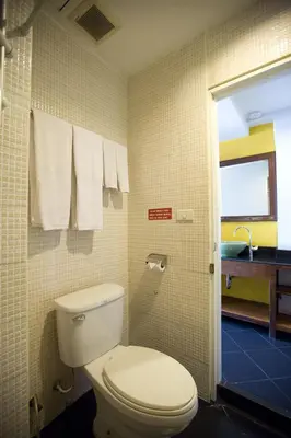 a bathroom with a toilet and a sink at Lamphu Tree House Boutique Hotel in Bangkok