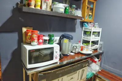 a counter with a microwave on top of it at Mahannop Hostel in Bangkok