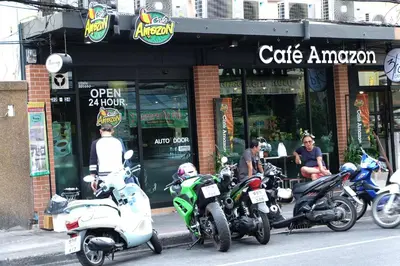 a group of motorcycles parked in front of a cafe amazon at Mahannop Hostel in Bangkok
