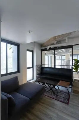 a living room with a couch and a piano at IR-ON Hotel in Bangkok