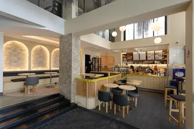 a restaurant with tables and chairs and a counter at IR-ON Hotel in Bangkok