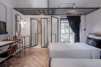 a hotel room with two beds and a table at IR-ON Hotel in Bangkok