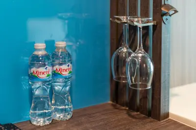 three bottles of water are sitting on a shelf at BB House Khlong Tan บีบีเฮ้าส์ คลองตัน in Bangkok
