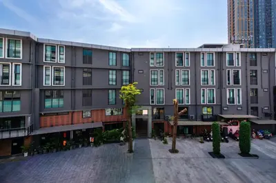 a large gray building with trees in front of it at BB House Khlong Tan บีบีเฮ้าส์ คลองตัน in Bangkok