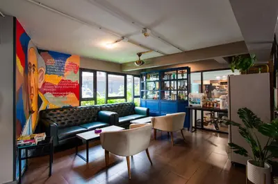 a living room with a couch and tables and chairs at BB House Khlong Tan บีบีเฮ้าส์ คลองตัน in Bangkok