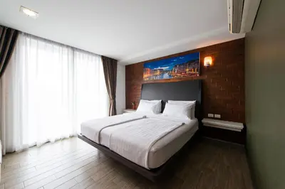 a bedroom with a large bed and a brick wall at BB House Khlong Tan บีบีเฮ้าส์ คลองตัน in Bangkok