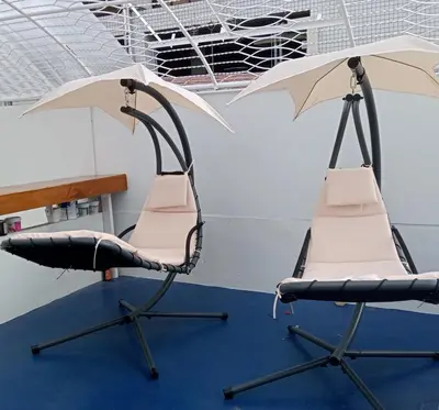 two chairs and an umbrella in a room at Hoft Hostel Bangkok in Bangkok