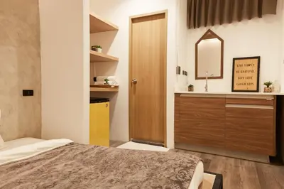 a bedroom with a bed and a vanity and a mirror at Vann Bangkok Boutique House in Bangkok