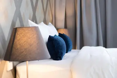 a bed with two pillows and two lamps on it at Klub Hotel Bangkok in Bangkok