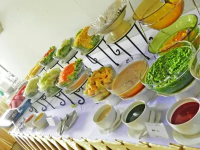 a bunch of plates of food on a shelf at Niran Grand Hotel in Bangkok
