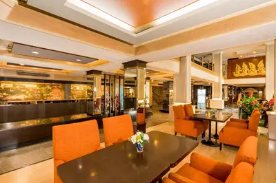a restaurant with orange chairs and a table at Niran Grand Hotel in Bangkok