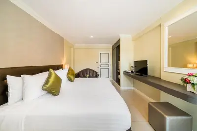 a hotel room with a bed and a television at Niran Grand Hotel in Bangkok