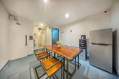 a kitchen with a wooden table and a refrigerator at RALPH Bangkok in Bangkok