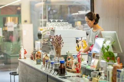 a woman standing behind a counter with a machine at RALPH Bangkok in Bangkok