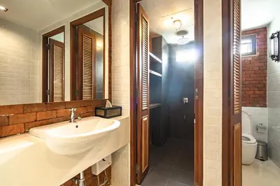 a bathroom with a sink and a shower and a toilet at Siam Plug In Hostel in Bangkok
