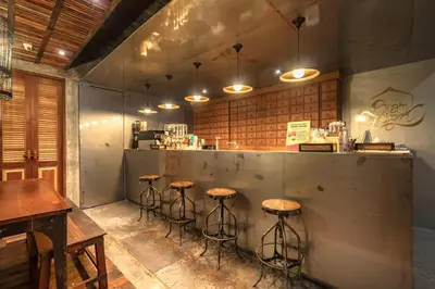 a bar with stools in front of a counter at Siam Plug In Hostel in Bangkok