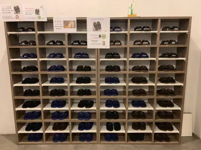 a display case filled with lots of shoes at Norn Yaowarat Hotel in Bangkok