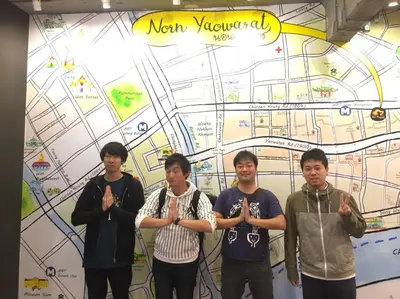 a group of young men standing in front of a map at Norn Yaowarat Hotel in Bangkok