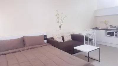 a living room with a couch and a table at Popular Condo C4 in Nonthaburi