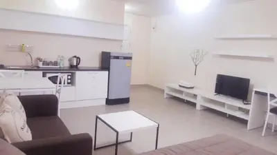 a living room with a couch and a kitchen at Popular Condo C4 in Nonthaburi